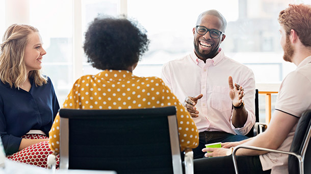 Group of 4 people, man speaking is smiling